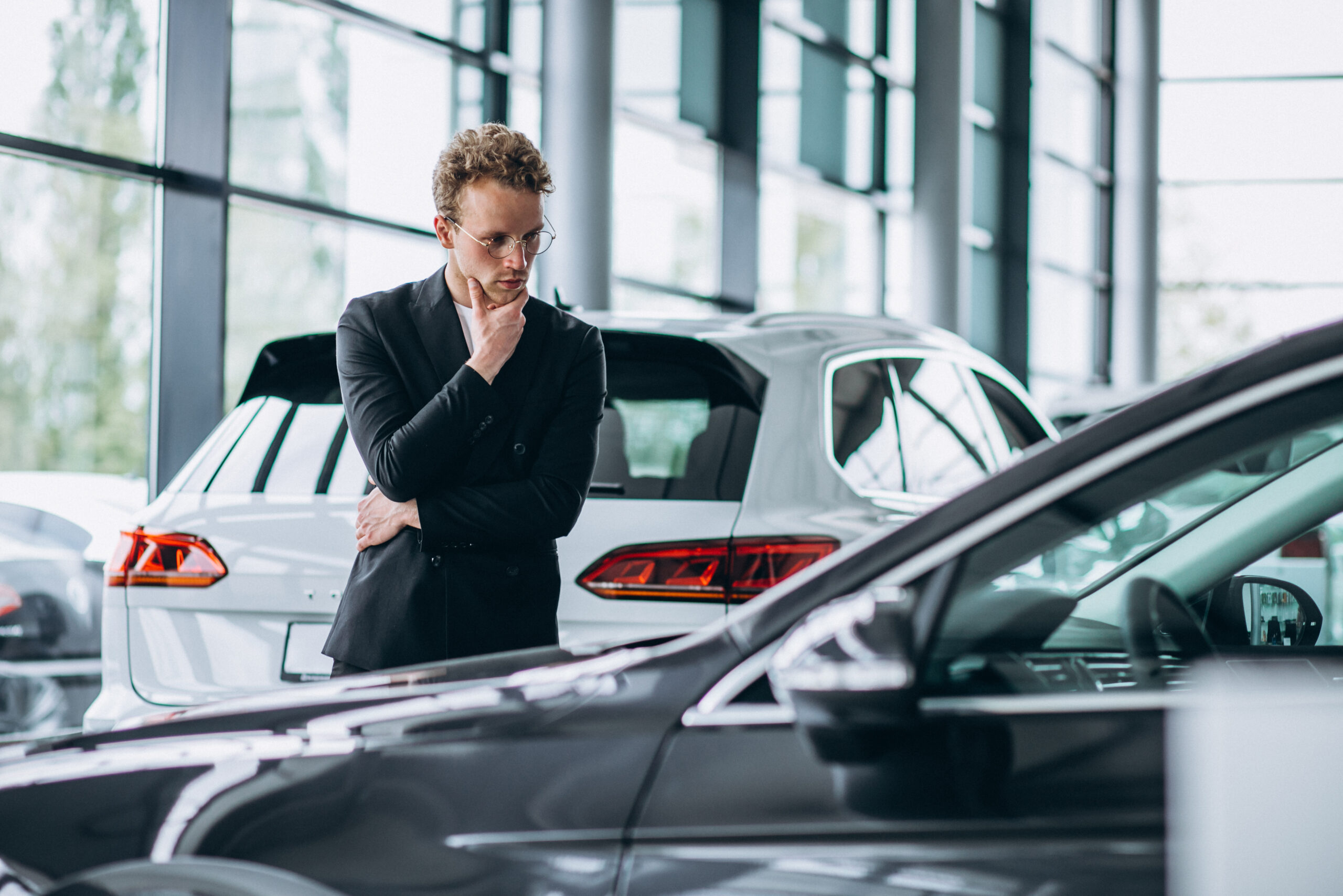 Man looking at a car and thinking of a purchase